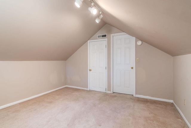 bonus room featuring light carpet, vaulted ceiling, and baseboards