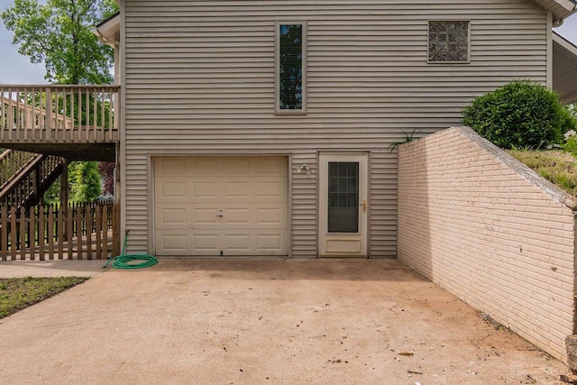 view of front of home with a garage, a deck, fence, and stairs