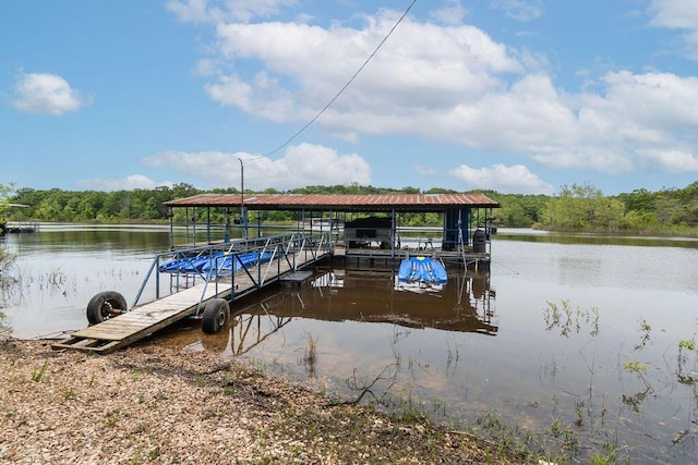 dock featuring a water view, a wooded view, and boat lift