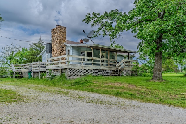 rear view of property featuring a deck and a chimney