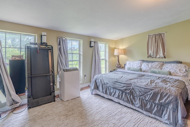 bedroom with wood finished floors, multiple windows, and baseboards