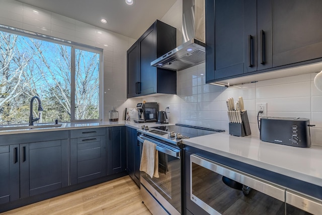 139 Cherokee Dr, Kimberling City, MO 65686 - kitchen with stainless steel electric range, wall chimney exhaust hood, light countertops, tasteful backsplash, and a sink