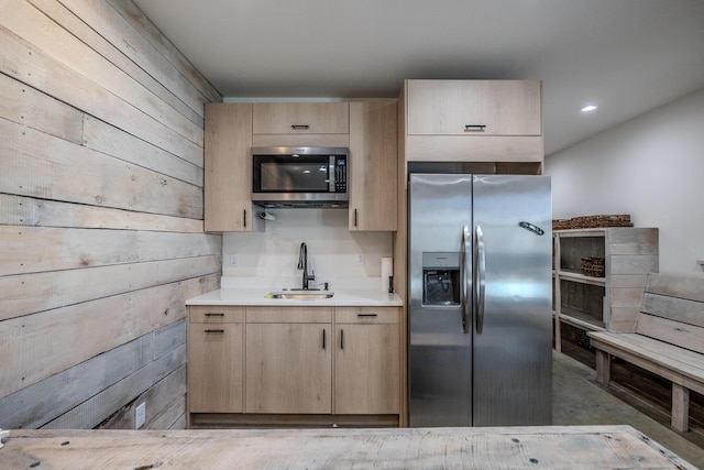 139 Cherokee Dr, Kimberling City, MO 65686 - kitchen featuring appliances with stainless steel finishes, light brown cabinetry, a sink, light countertops, and wooden walls