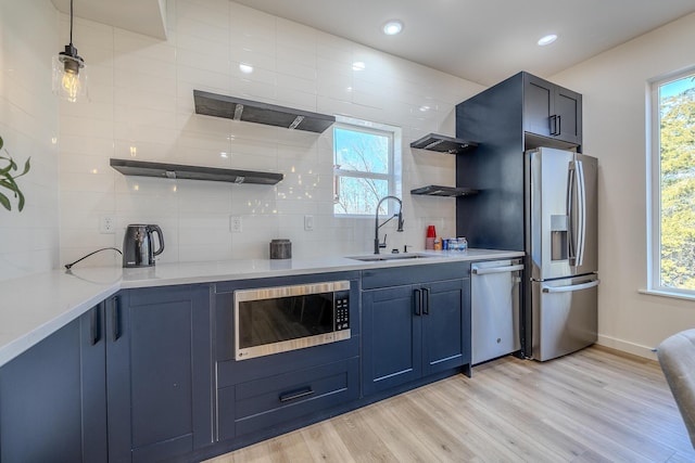 139 Cherokee Dr, Kimberling City, MO 65686 - kitchen featuring stainless steel appliances, open shelves, a sink, blue cabinetry, and decorative backsplash
