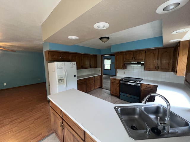 9556 N State Highway H, Pleasant Hope, MO 65725 - kitchen with electric range, white fridge with ice dispenser, a sink, under cabinet range hood, and tasteful backsplash