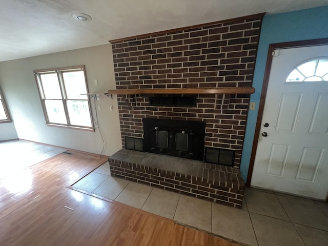 9556 N State Highway H, Pleasant Hope, MO 65725 - unfurnished living room with a brick fireplace, plenty of natural light, and wood finished floors