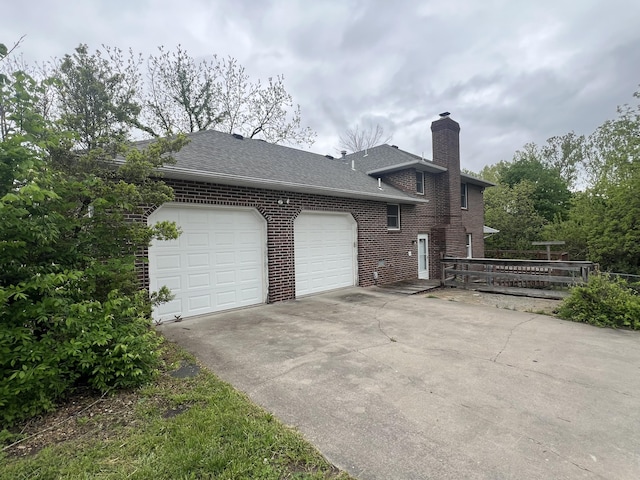 9556 N State Highway H, Pleasant Hope, MO 65725 - view of side of property with brick siding, driveway, a garage, a chimney, and a shingled roof