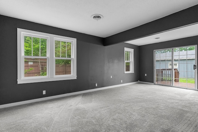carpeted empty room featuring baseboards