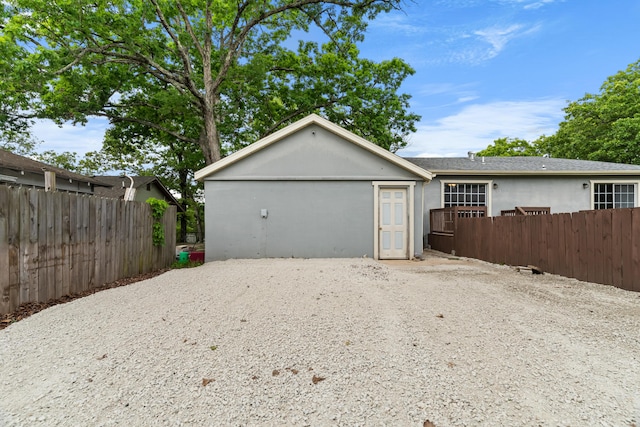 view of front facade featuring fence, stucco siding, and driveway