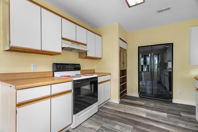 kitchen featuring electric range, under cabinet range hood, black fridge, wood finished floors, and white cabinets