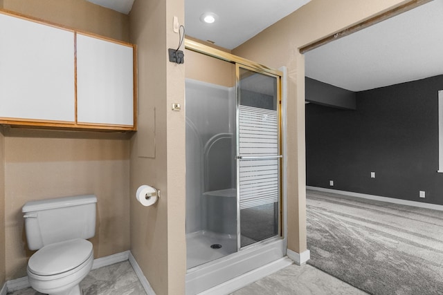 bathroom with a shower stall, baseboards, and toilet