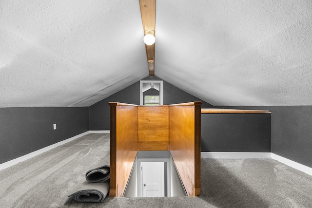 additional living space featuring carpet flooring, a textured ceiling, baseboards, and vaulted ceiling