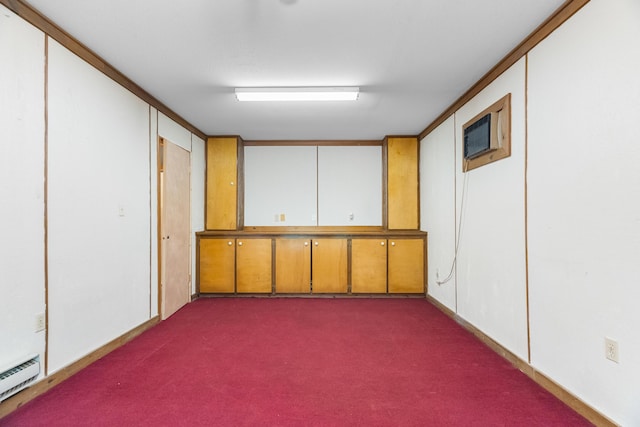 unfurnished room with baseboard heating and dark colored carpet