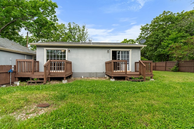 rear view of property featuring a deck and stucco siding