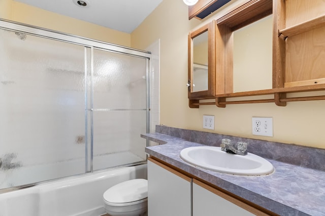 full bath featuring toilet, vanity, and bath / shower combo with glass door