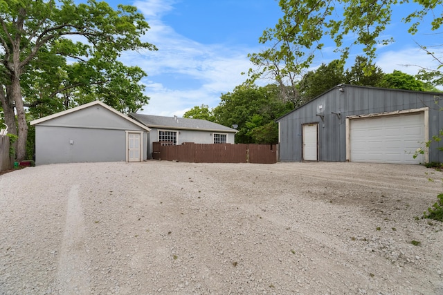 detached garage featuring fence and driveway