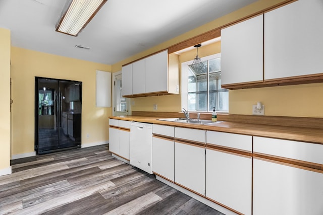 kitchen with a sink, white dishwasher, white cabinetry, and wood finished floors