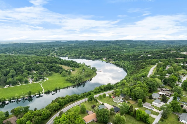 aerial view of property and surrounding area featuring a forest and a large body of water
