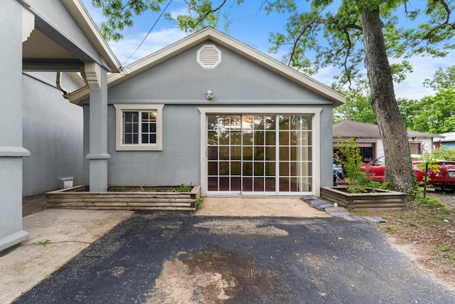 rear view of property featuring stucco siding