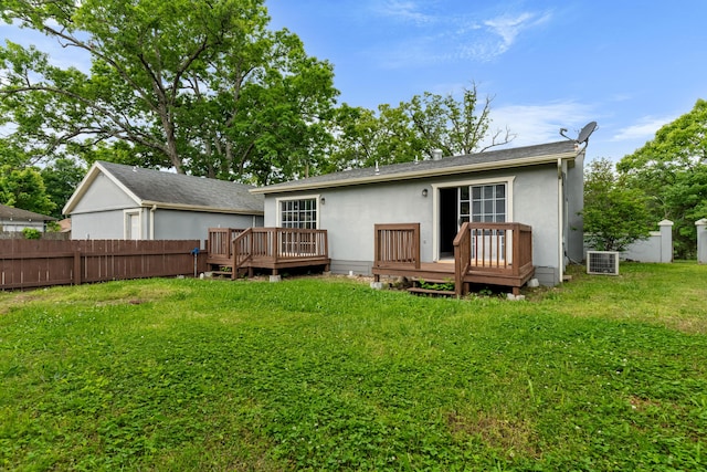 rear view of property with a deck, stucco siding, and central AC