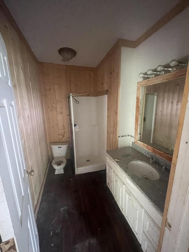 421 N Phelps St, Mansfield, MO 65704 - bathroom with a stall shower, toilet, vanity, wooden walls, and wood finished floors