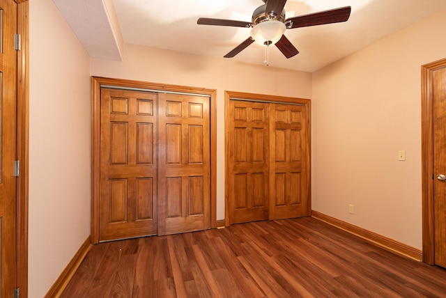 143 Woodfield Dr, Highlandville, MO 65669 - unfurnished bedroom featuring dark wood-type flooring, two closets, baseboards, and ceiling fan