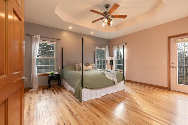 143 Woodfield Dr, Highlandville, MO 65669 - bedroom with light wood-style floors, a tray ceiling, recessed lighting, multiple windows, and baseboards