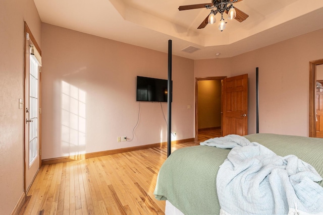 143 Woodfield Dr, Highlandville, MO 65669 - bedroom featuring light wood-style flooring, a tray ceiling, baseboards, and ceiling fan