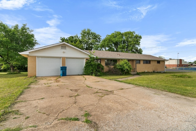 ranch-style home with brick siding, a front yard, driveway, and a garage