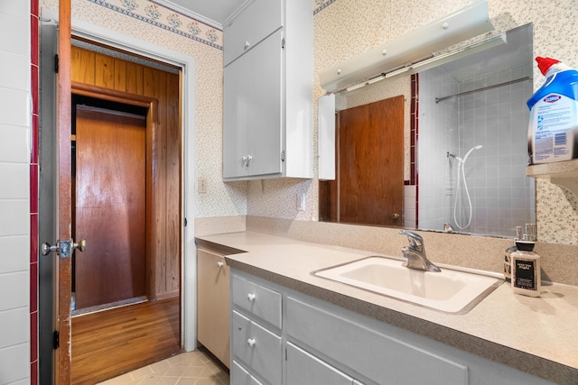kitchen with a sink, wallpapered walls, and gray cabinetry