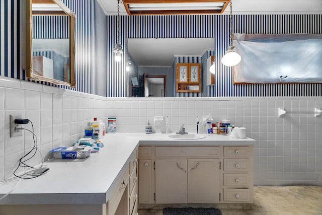 bathroom with vanity, wallpapered walls, and tile walls