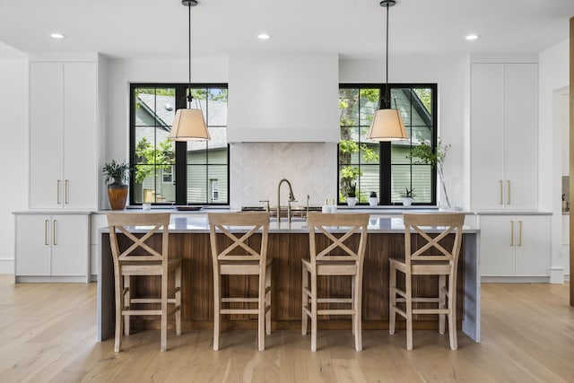 273 Secret Ln, Branson West, MO 65737 - kitchen with modern cabinets, white cabinetry, backsplash, light wood-style floors, and a kitchen island with sink