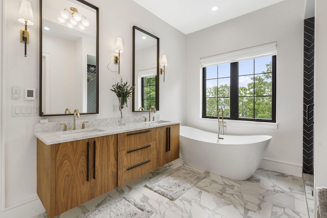 273 Secret Ln, Branson West, MO 65737 - bathroom with marble finish floors, a freestanding tub, double vanity, recessed lighting, and baseboards