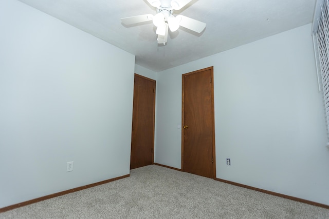 unfurnished room with light carpet, baseboards, and ceiling fan