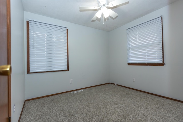 carpeted spare room featuring ceiling fan and baseboards