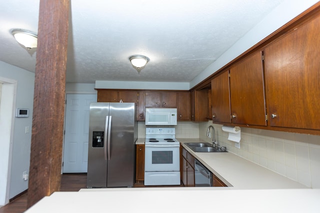 kitchen featuring appliances with stainless steel finishes, a sink, light countertops, and backsplash