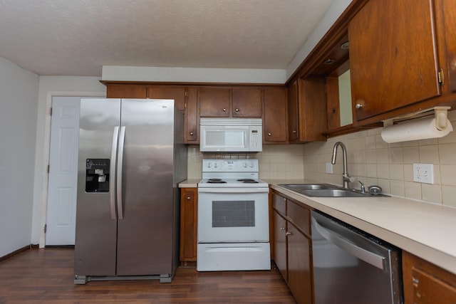 kitchen with stainless steel appliances, a sink, light countertops, backsplash, and a textured ceiling