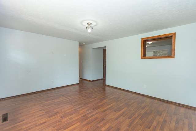 spare room with wood finished floors and baseboards