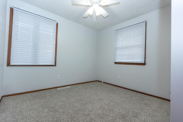 spare room with carpet floors, ceiling fan, and baseboards