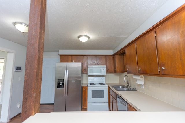 kitchen with appliances with stainless steel finishes, a sink, light countertops, decorative backsplash, and a textured ceiling