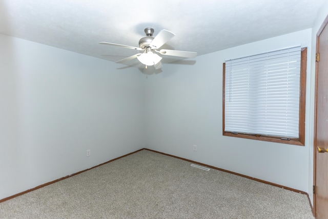 spare room with carpet flooring, ceiling fan, and baseboards