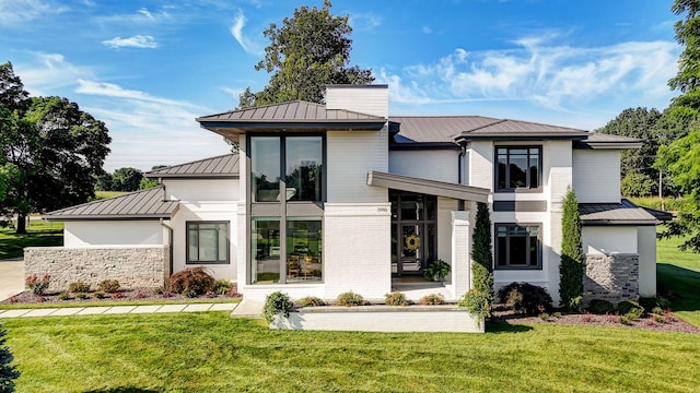 3900 E Dunrobin Dr, Springfield, MO 65809 - contemporary home featuring a standing seam roof, a metal roof, a front yard, and stone siding