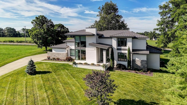 3900 E Dunrobin Dr, Springfield, MO 65809 - modern home featuring a standing seam roof, a metal roof, stone siding, and a front lawn