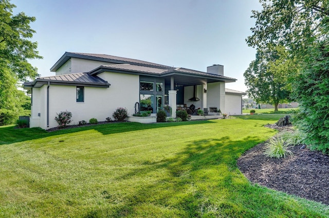 3900 E Dunrobin Dr, Springfield, MO 65809 - rear view of house featuring a chimney, a lawn, and a metal roof