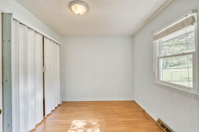 4852 S Charleston Ave, Springfield, MO 65804 - unfurnished bedroom featuring a textured ceiling, light wood finished floors, a closet, and baseboards
