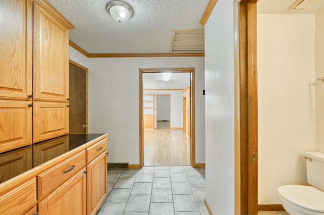 4852 S Charleston Ave, Springfield, MO 65804 - bathroom with toilet, a textured ceiling, ornamental molding, and baseboards