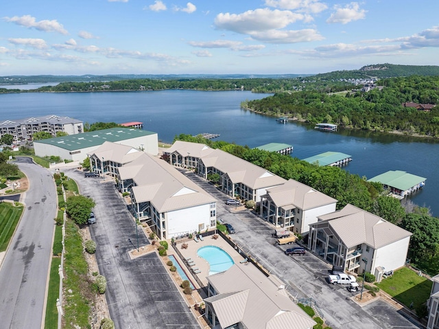 drone / aerial view of a nearby body of water and a pool area