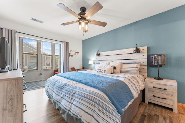 bedroom featuring wood finished floors, access to exterior, a ceiling fan, and baseboards