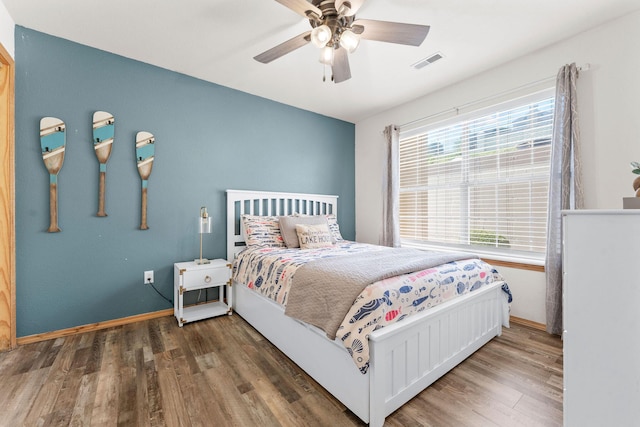 bedroom featuring wood finished floors, baseboards, and a ceiling fan