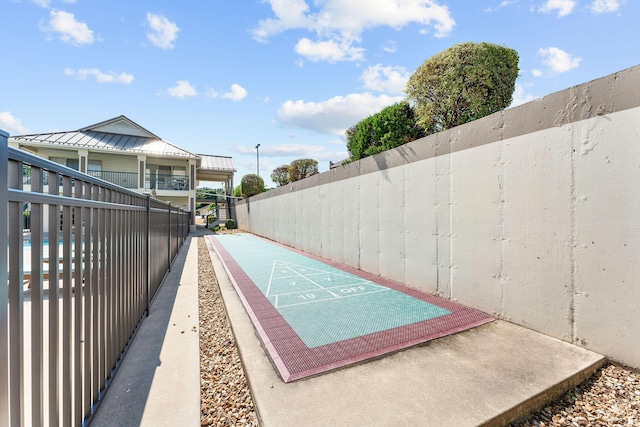 view of community featuring shuffleboard and fence